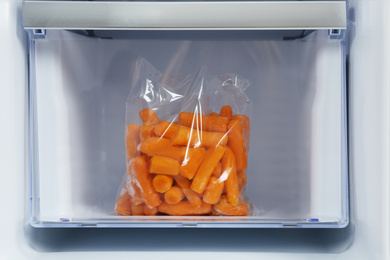 Photo of Pack of carrot on drawer of refrigerator