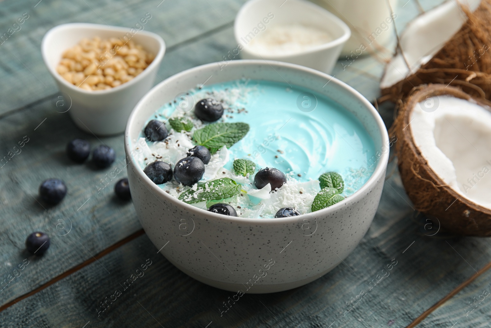 Photo of Bowl of spirulina smoothie served on wooden background