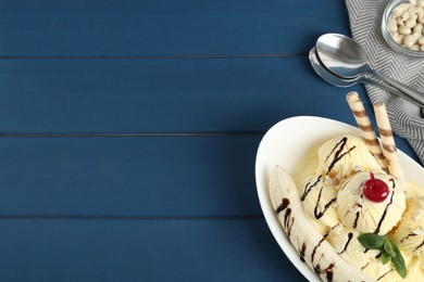 Photo of Delicious dessert with banana ice cream on blue wooden table, flat lay. Space for text