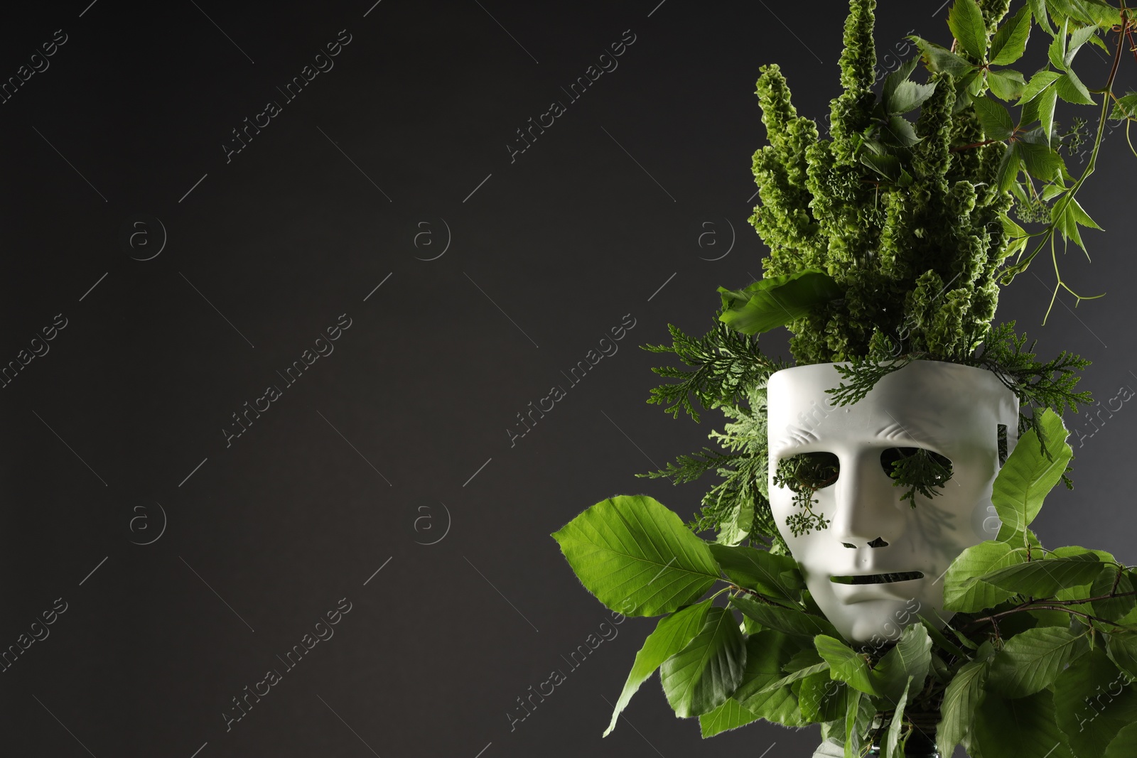 Photo of Theatrical performance. Plastic mask and floral decor on black background, space for text