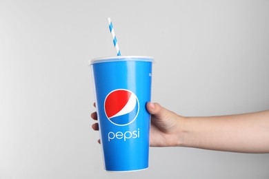 MYKOLAIV, UKRAINE - JUNE 9, 2021: Woman holding paper Pepsi cup on white background, closeup