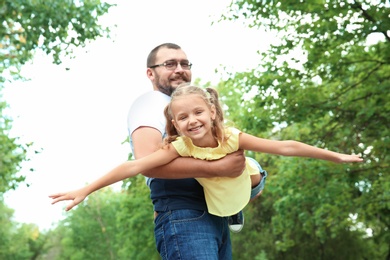 Photo of Father playing with his child outdoors. Happy family