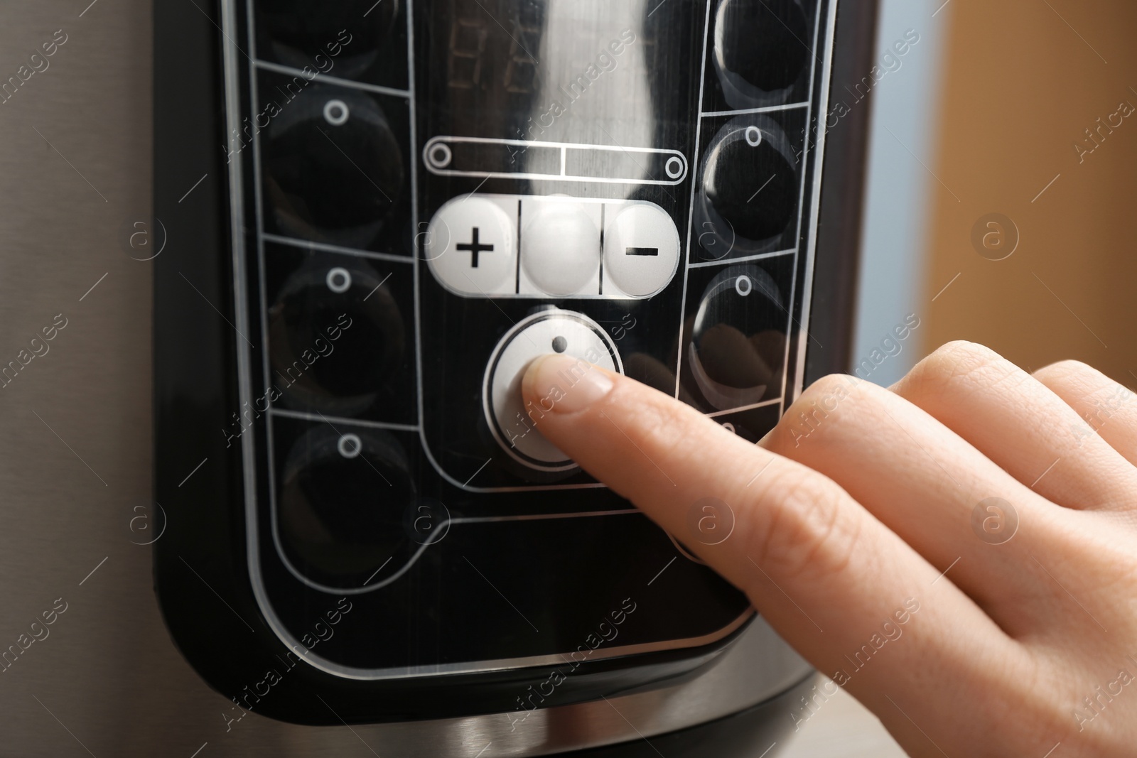 Photo of Woman turning on modern electric multi cooker, closeup