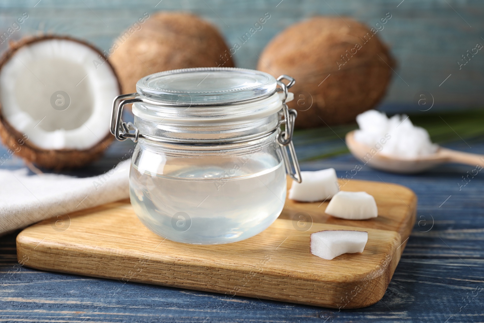 Photo of Coconut oil in jar on blue wooden table