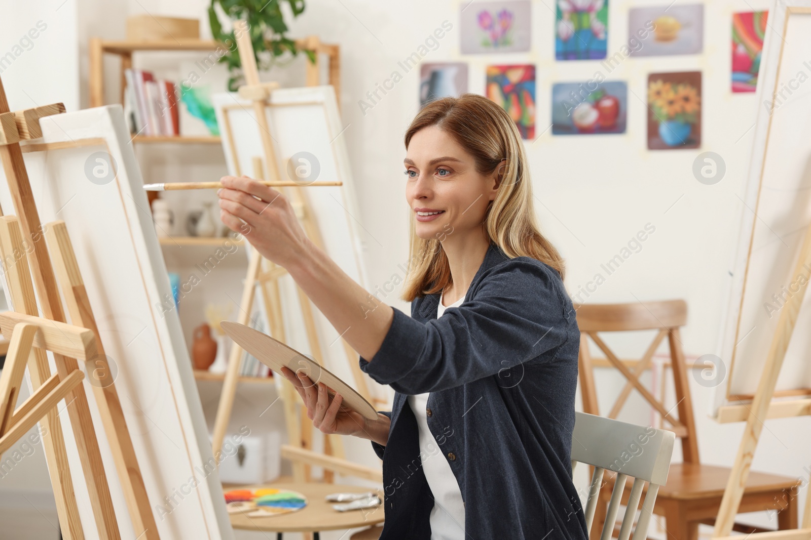 Photo of Beautiful woman painting in studio. Creative hobby