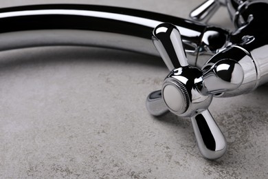 Photo of Double handle water tap on grey table, closeup