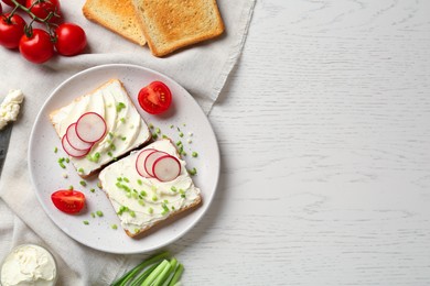 Photo of Toasted bread with cream cheese and vegetables on white wooden table, flat lay. Space for text