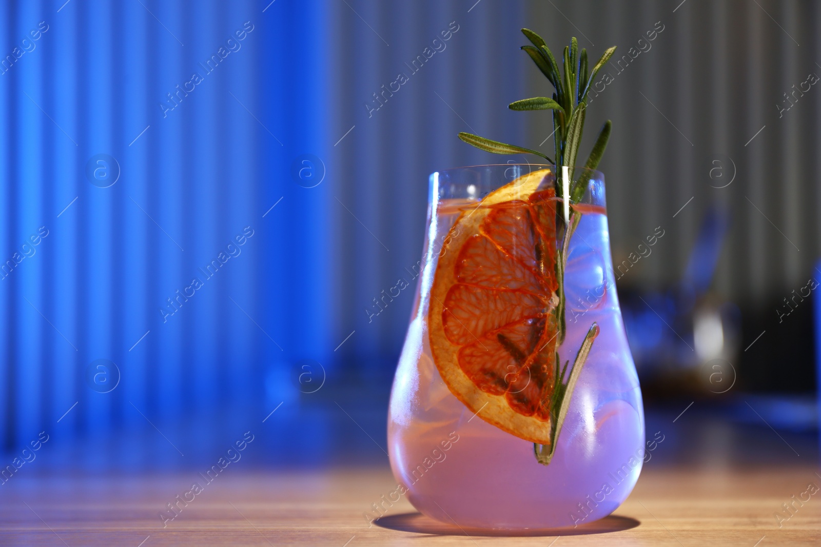 Photo of Glass of delicious cocktail with vodka on wooden counter in bar. Space for text