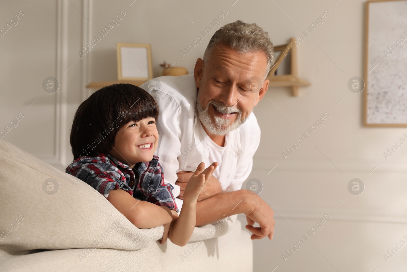 Photo of Happy grandfather spending time with his grandson at home