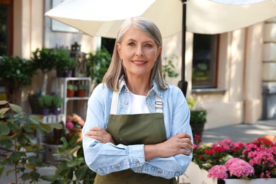 Photo of Portrait of happy business owner near her flower shop outdoors