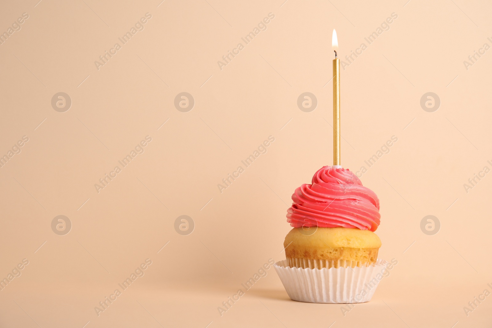 Photo of Birthday cupcake with candle on beige background, space for text