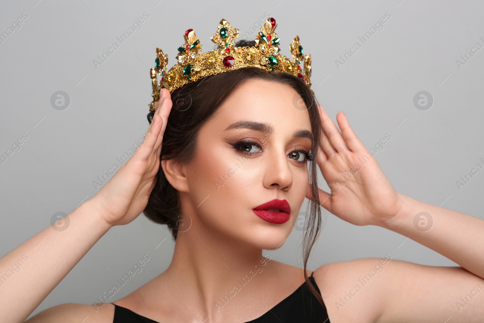 Photo of Beautiful young woman wearing luxurious crown on light grey background