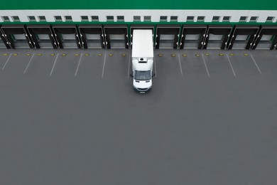 Image of Truck near loading dock of warehouse outdoors, aerial view. Logistics center