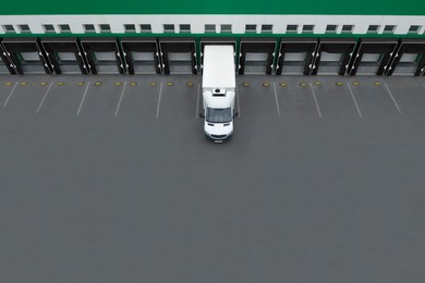 Truck near loading dock of warehouse outdoors, aerial view. Logistics center