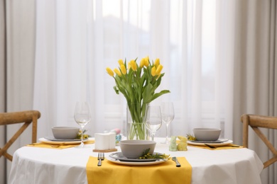 Beautiful Easter table setting with floral decor indoors