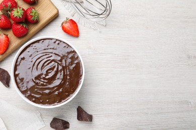 Delicious chocolate cream and strawberries on white wooden table, flat lay