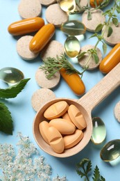 Photo of Different pills and herbs on light blue background, flat lay. Dietary supplements