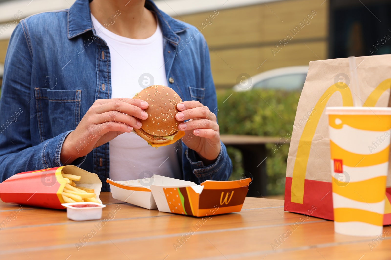 Photo of Lviv, Ukraine - October 9, 2023: Woman with McDonald's menu at table outdoors, closeup