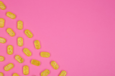 Photo of Many delicious lemon drops on pink background, flat lay. Space for text