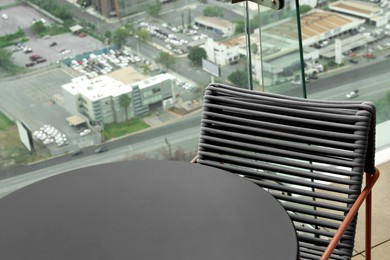 Coffee table and chair against picturesque landscape of city in cafe, closeup