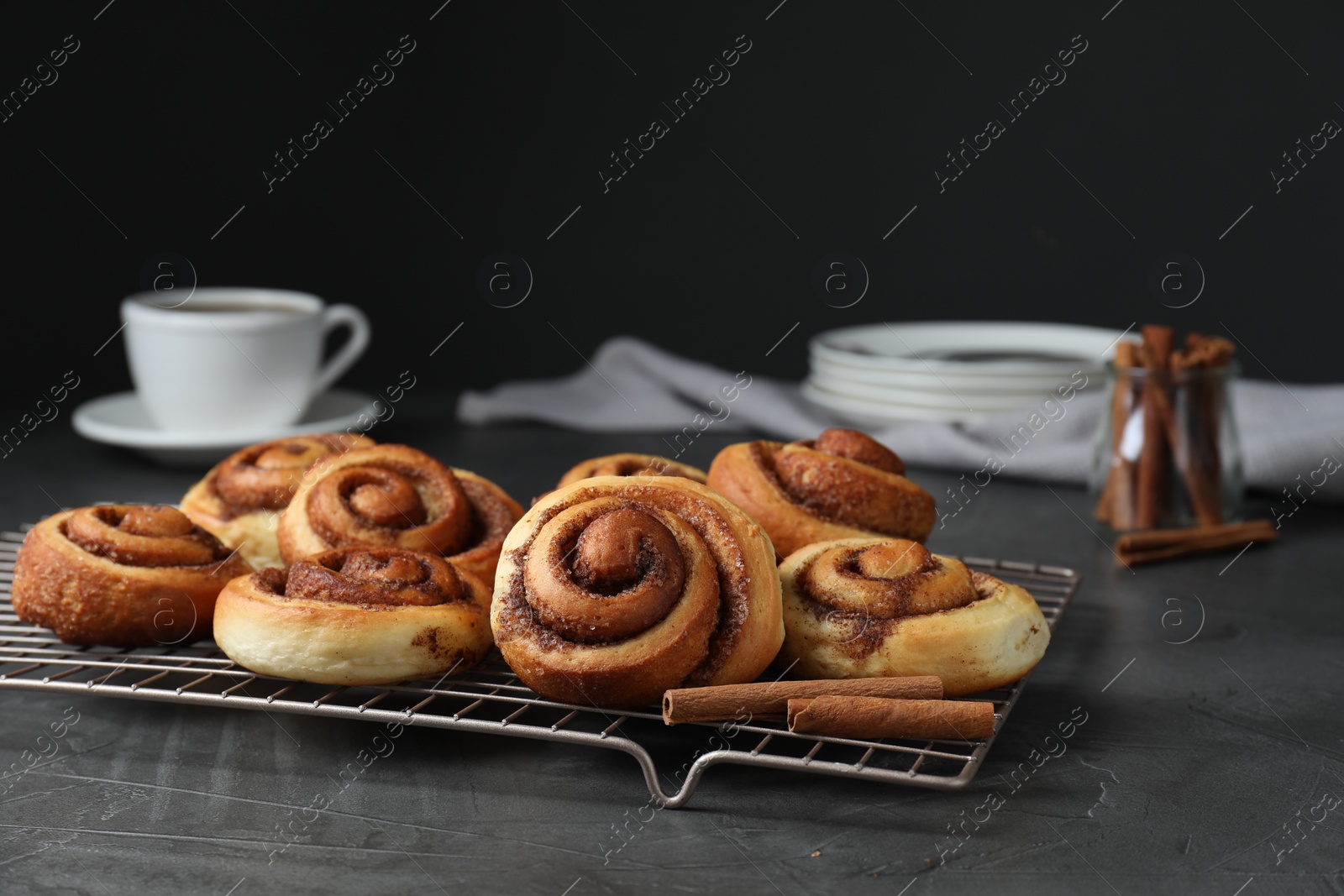 Photo of Tasty cinnamon rolls on black table, space for text