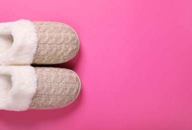 Photo of Pair of beautiful soft slippers on pink background, top view. Space for text