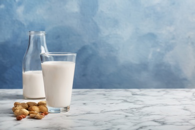 Photo of Glass and bottle with peanut milk on light table