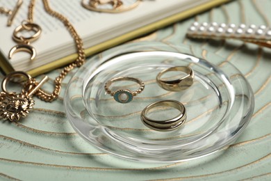 Photo of Stylish golden bijouterie on table, closeup. Elegant accessories