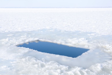 Photo of Ice hole in river on winter day. Baptism ritual