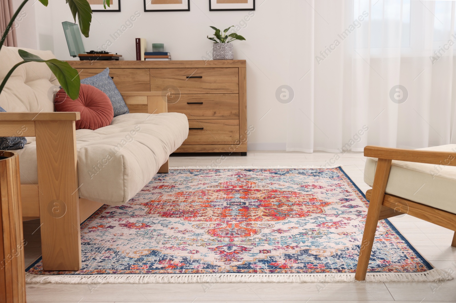 Photo of Beautiful rug, sofa and chest of drawers indoors