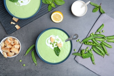 Flat lay composition with green pea soup on grey background