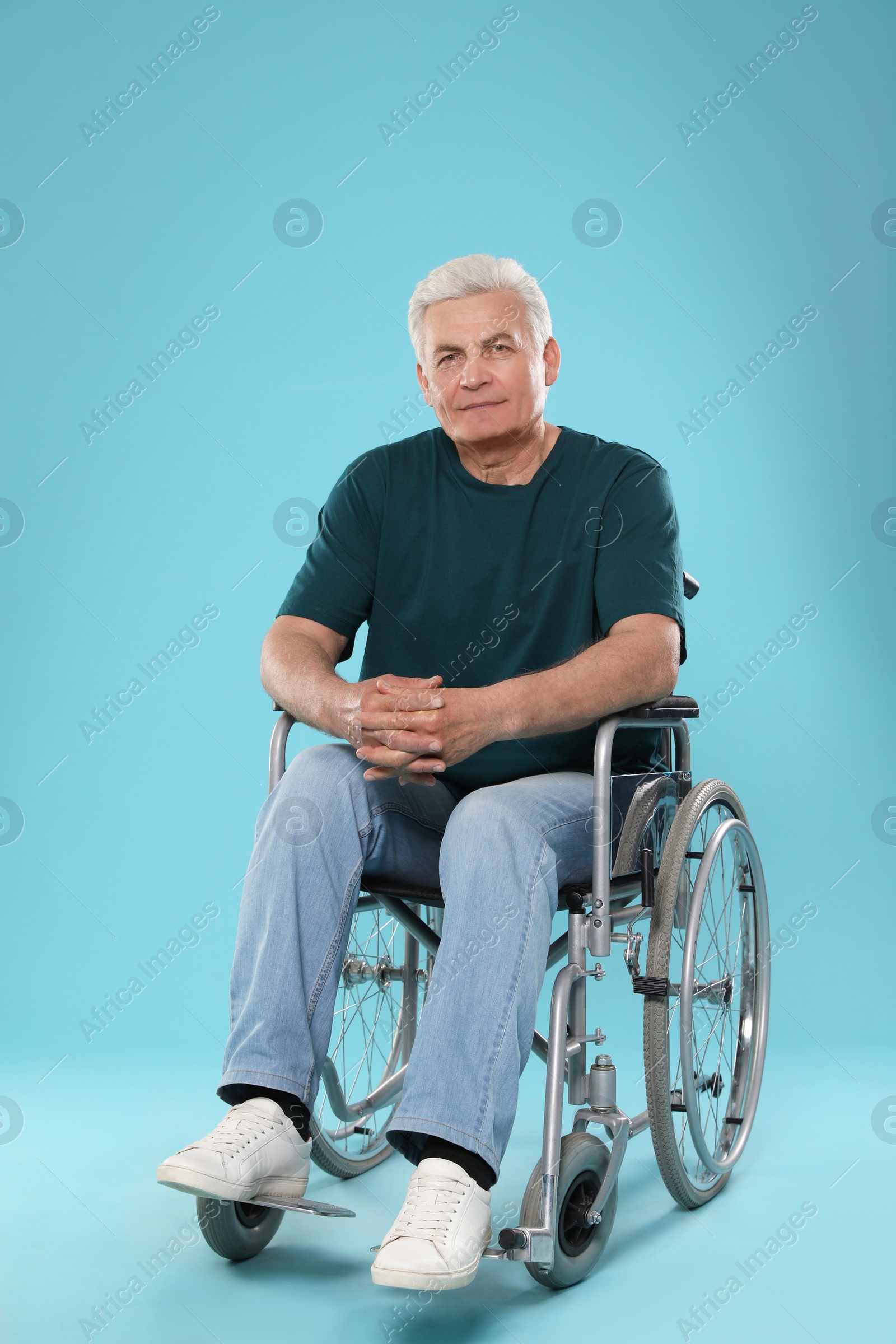 Photo of Senior man in wheelchair on color background