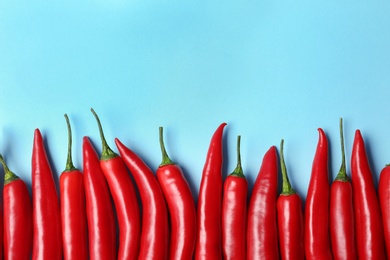 Flat lay composition with chili peppers on color background