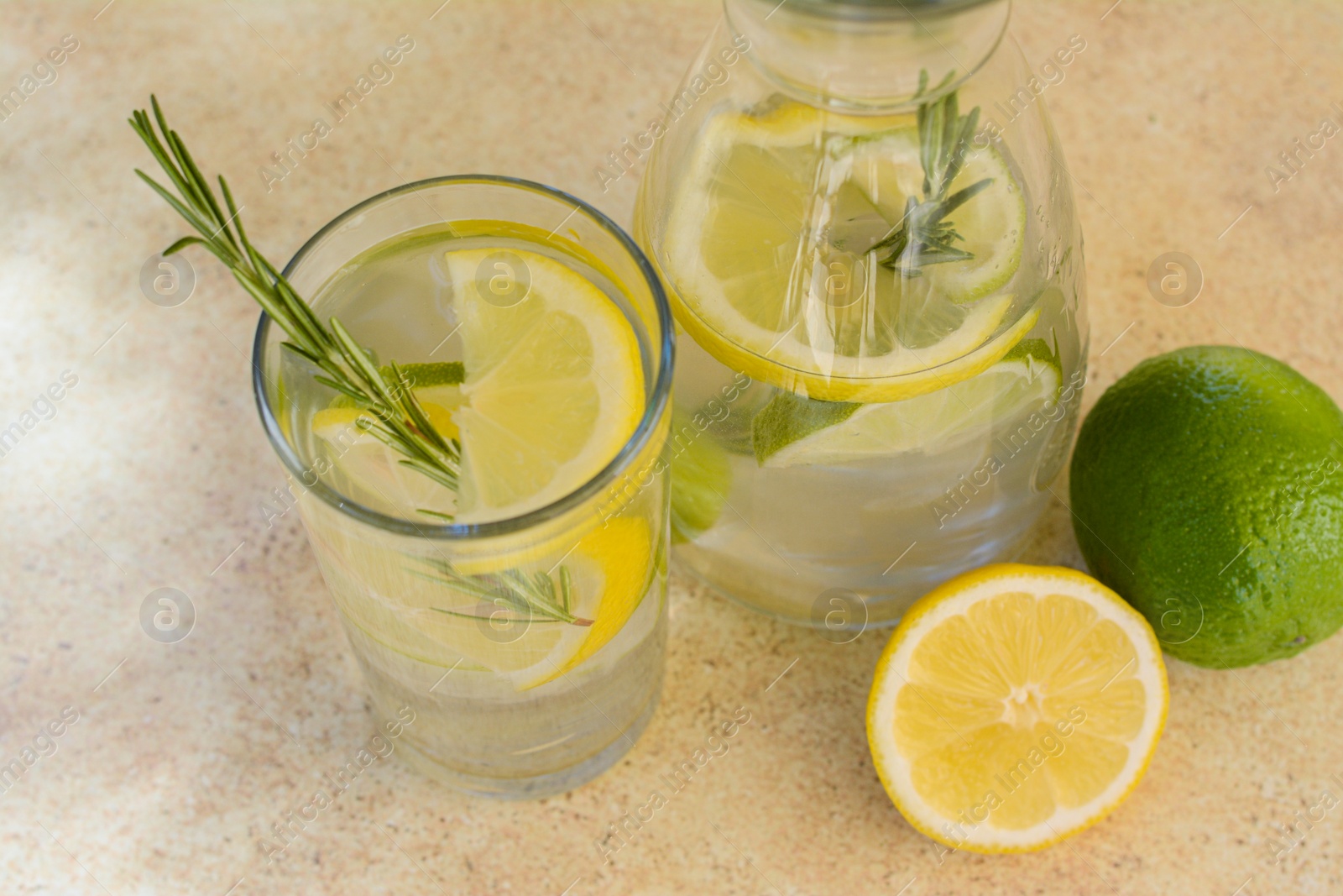 Photo of Tasty refreshing lemonade and ingredients on light table. Summer drink