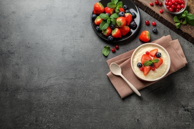 Photo of Delicious semolina pudding with berries and mint served on grey table, flat lay. Space for text