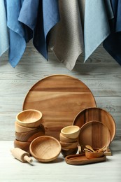 Set of clean wooden dishware and utensils on table