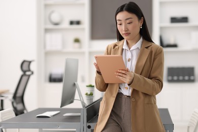 Photo of Portrait of beautiful businesswoman with tablet in office. Space for text