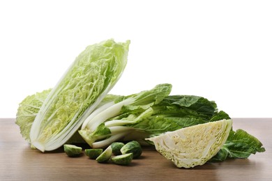 Photo of Different types of cut cabbage on wooden table against white background