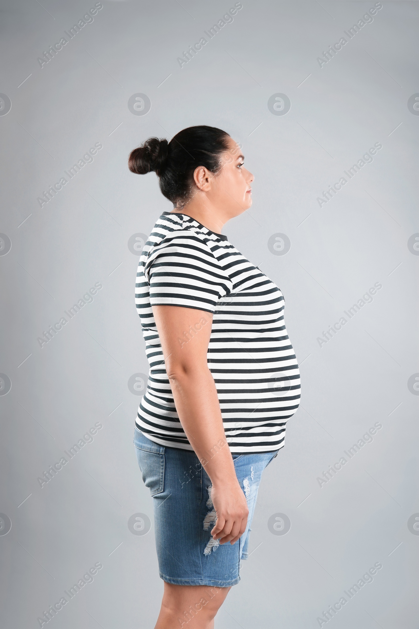 Photo of Fat woman on grey background. Weight loss