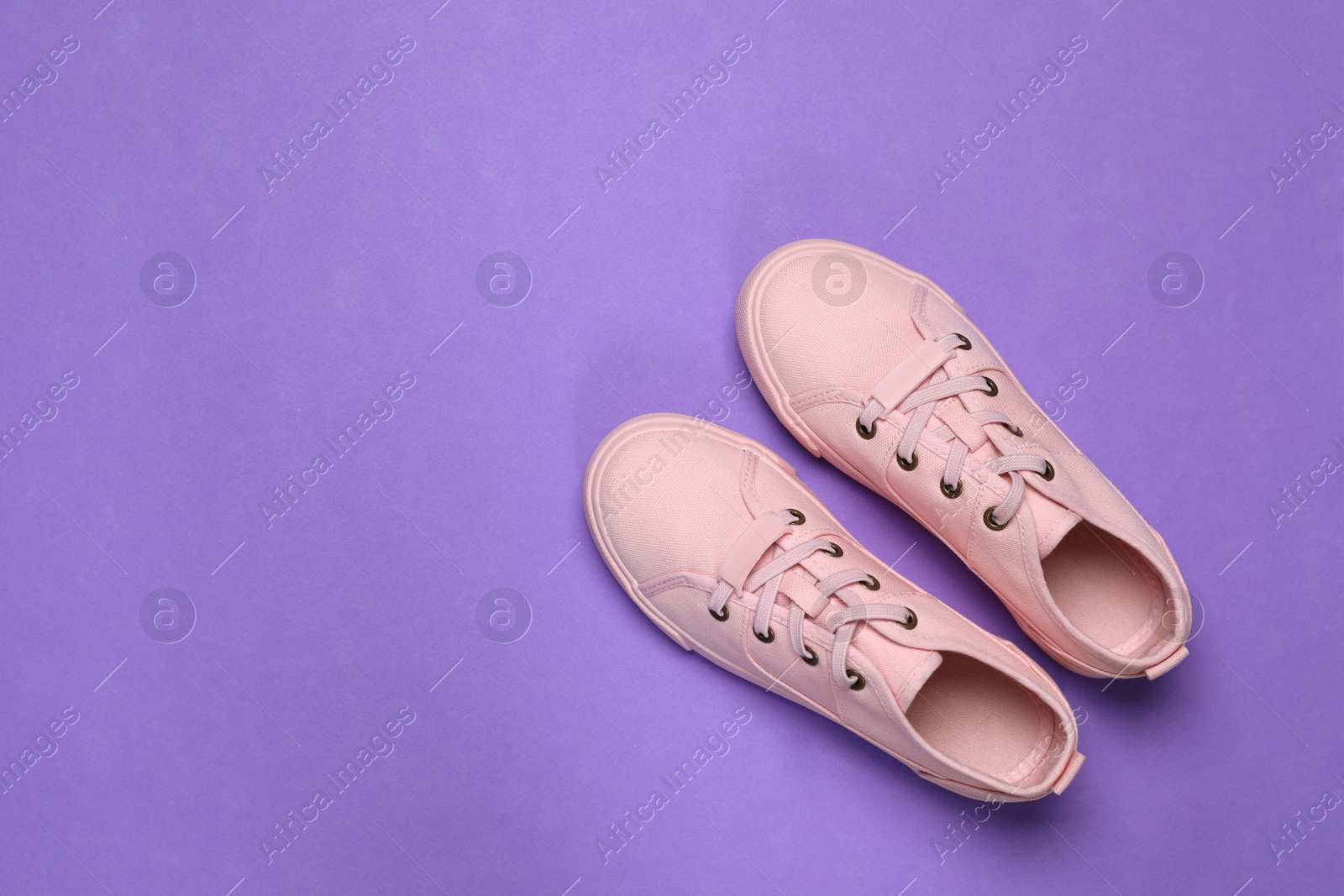 Photo of Pair of comfortable sports shoes on violet background, flat lay. Space for text