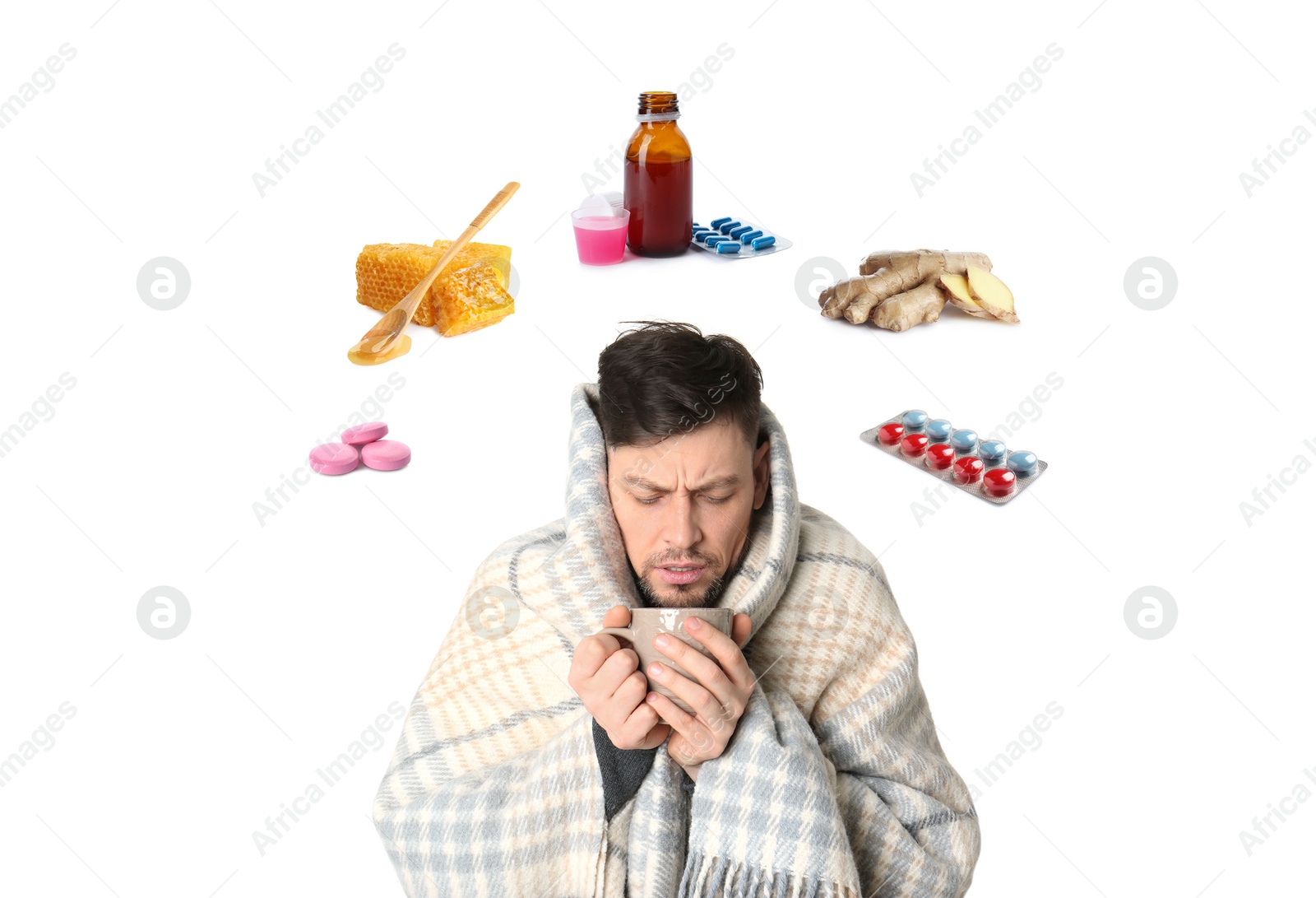 Image of SIck man with cup of hot drink surrounded by different drugs and products for illness treatment on white background