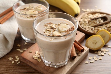Photo of Tasty banana smoothie with oatmeal and cinnamon on wooden table