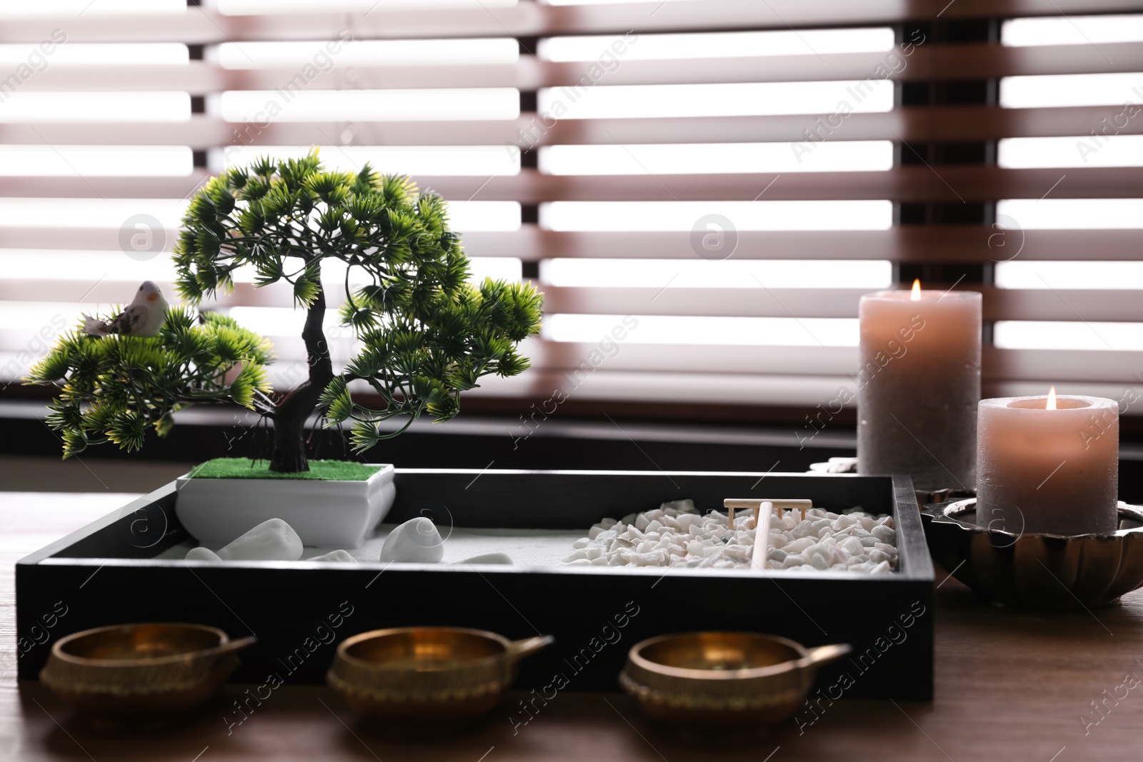 Photo of Beautiful miniature zen garden, candles and oil lamps on wooden table