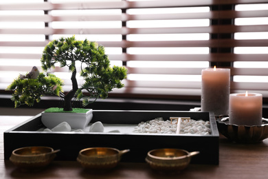 Photo of Beautiful miniature zen garden, candles and oil lamps on wooden table