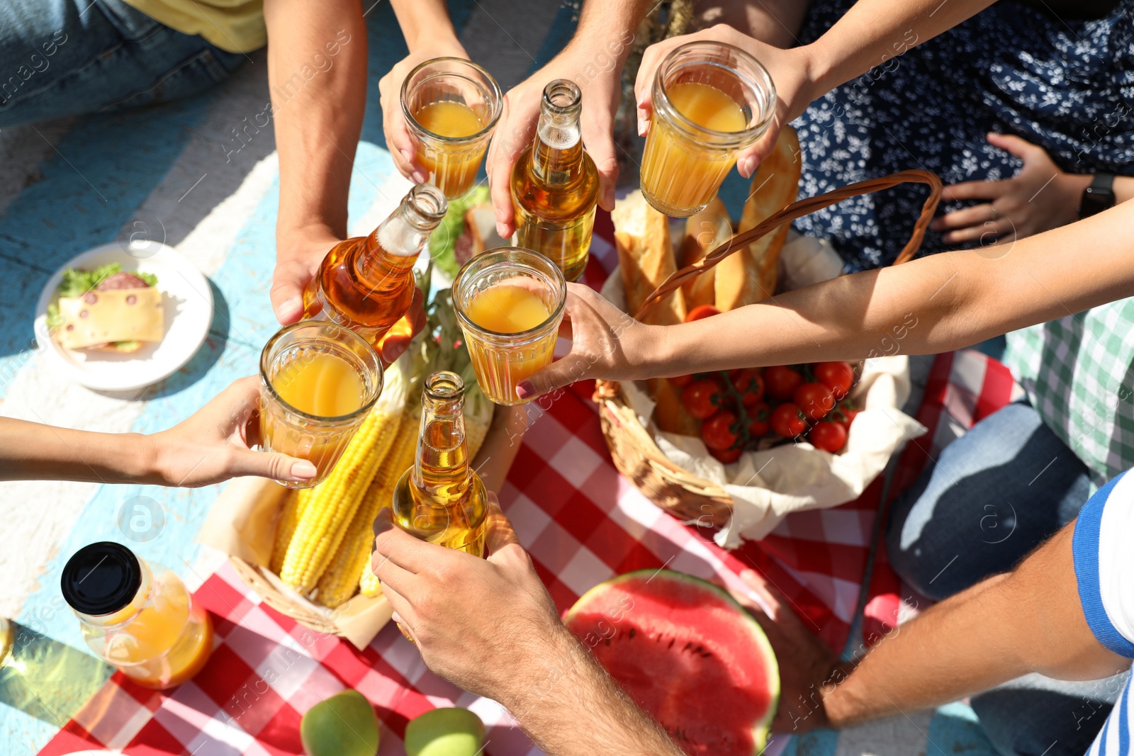 Photo of Young people enjoying picnic in park on summer day, top view