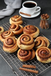 Photo of Tasty cinnamon rolls served on black table