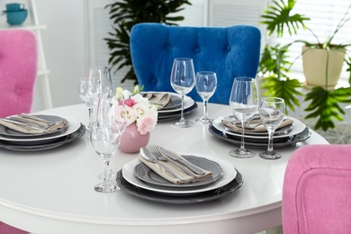 Photo of Beautiful table setting in modern dining room interior