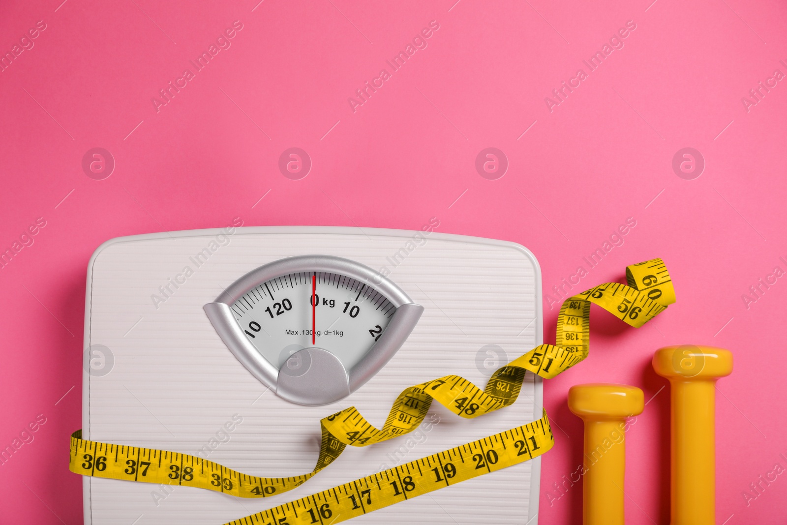 Photo of Weight loss concept. Scales, dumbbells and measuring tape on pink background, flat lay. Space for text