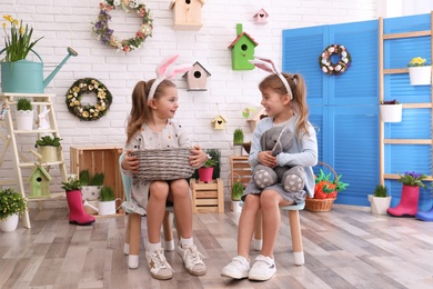 Photo of Adorable little girls with bunny ears in Easter photo zone