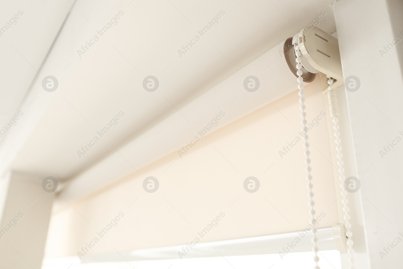 Photo of Window with modern roll blinds in room, closeup